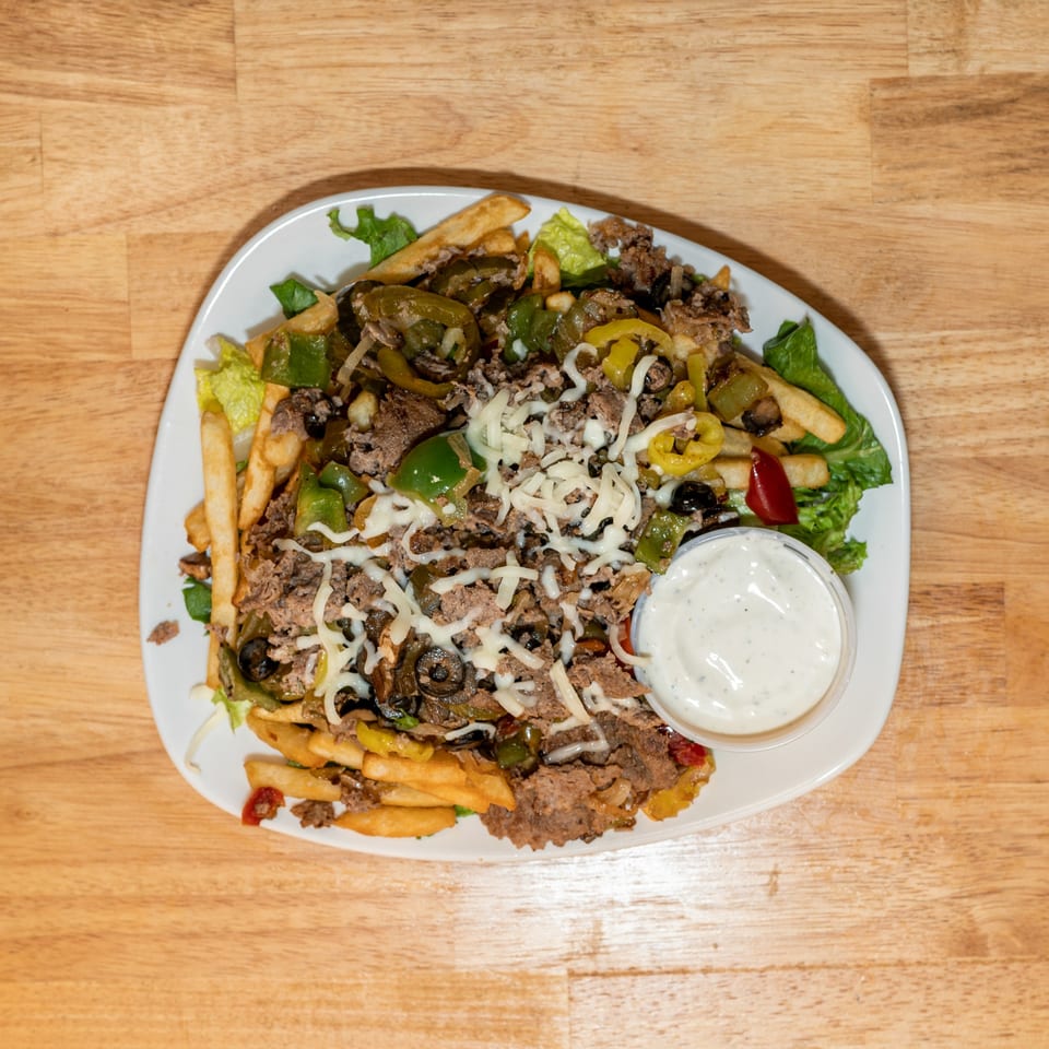 Cheesesteak fries with peppers, onions, olives, and shredded cheese, served with a side of ranch.